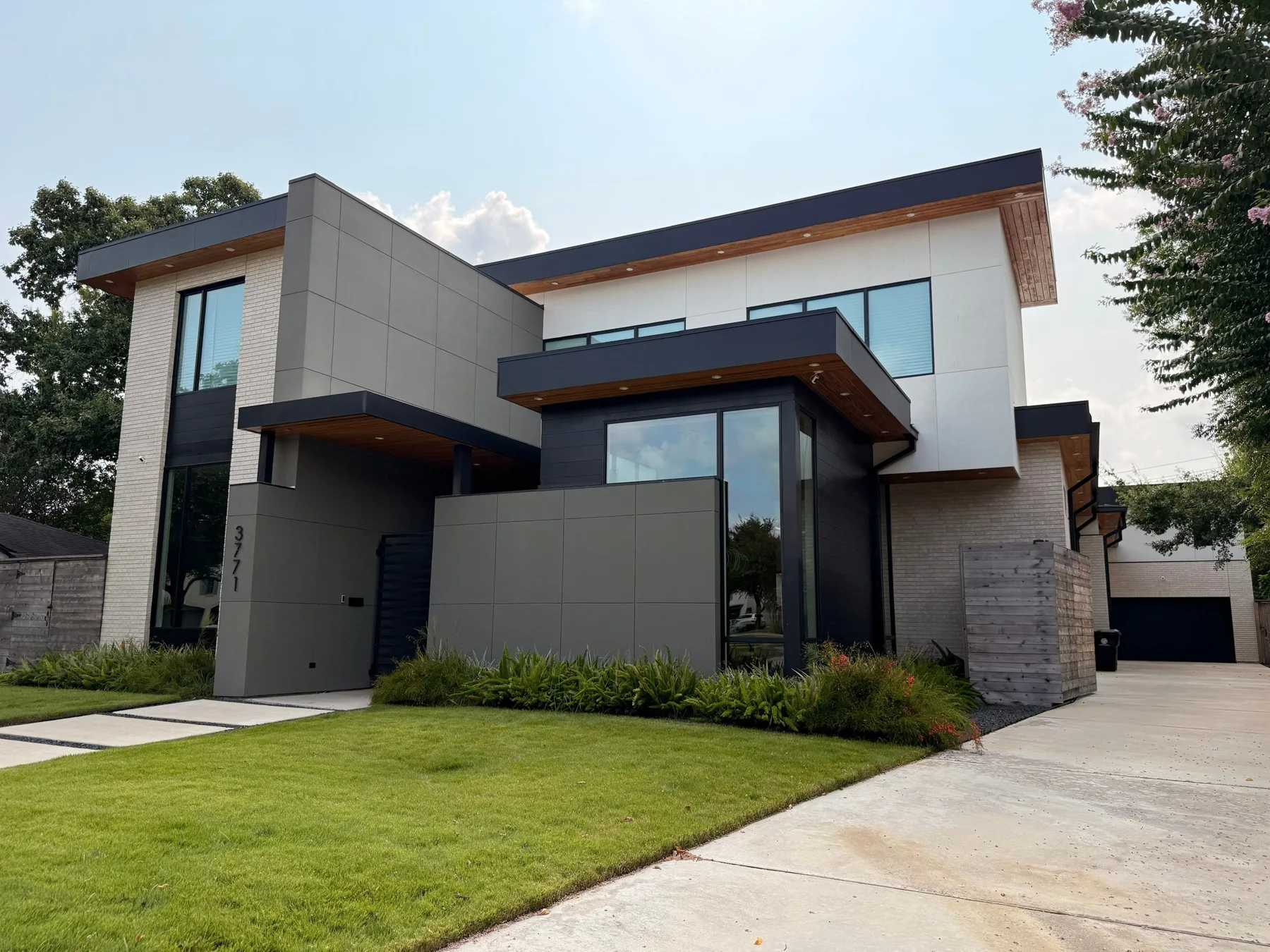 Modern home with gray stucco, stone accents, and black-framed windows