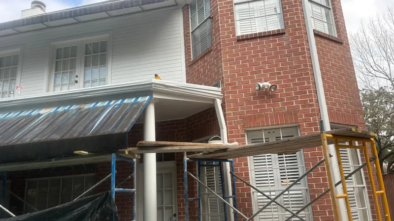 Brick exterior and covered balcony with scaffolding in place