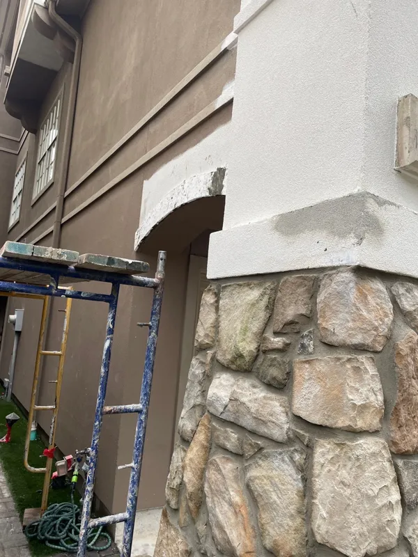 Stucco trim meeting a stone exterior wall