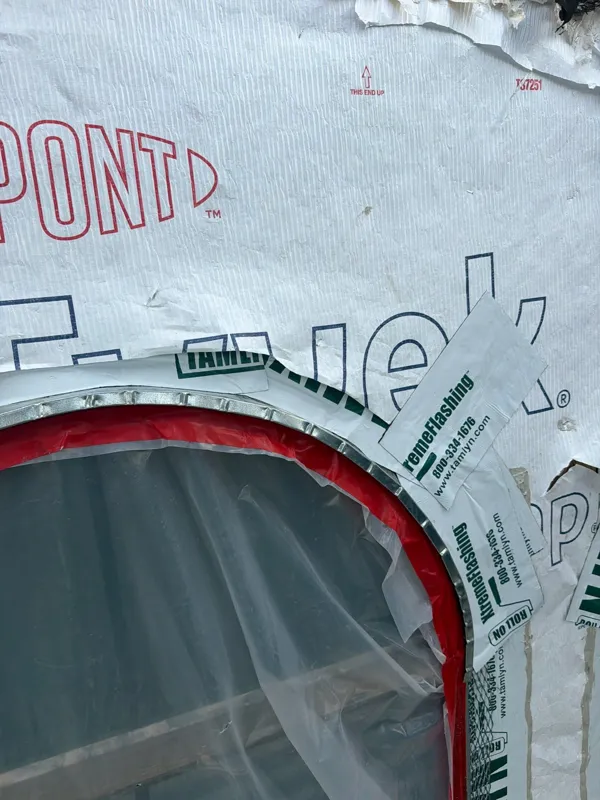 Weather barrier installed around the arched window
