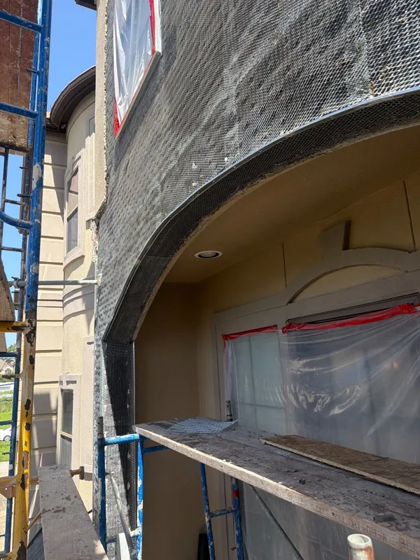 Metal lath following the curve of an arched window