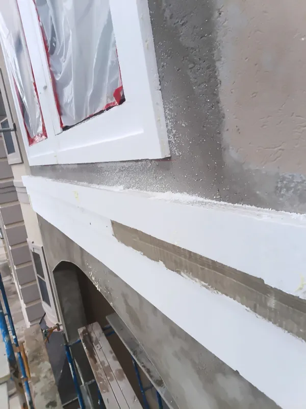 Stucco coat and trim around a protected window