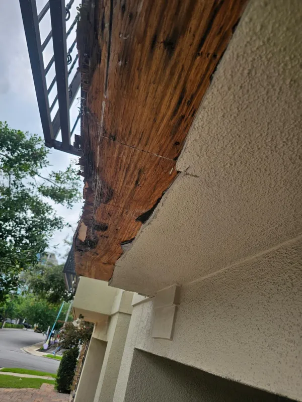 Wood exposed beneath a balcony railing