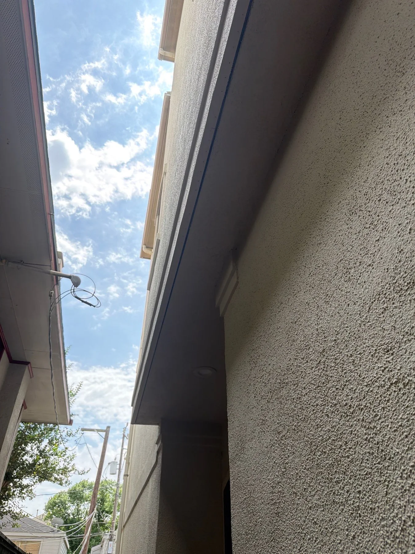 Smooth soffit and textured stucco wall in a later view