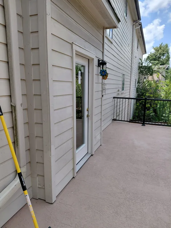 Siding and doorway opening onto a balcony