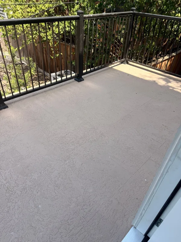 Gray balcony surface bordered by a dark railing