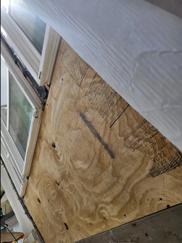 Wood sheathing beside a window during exterior repairs