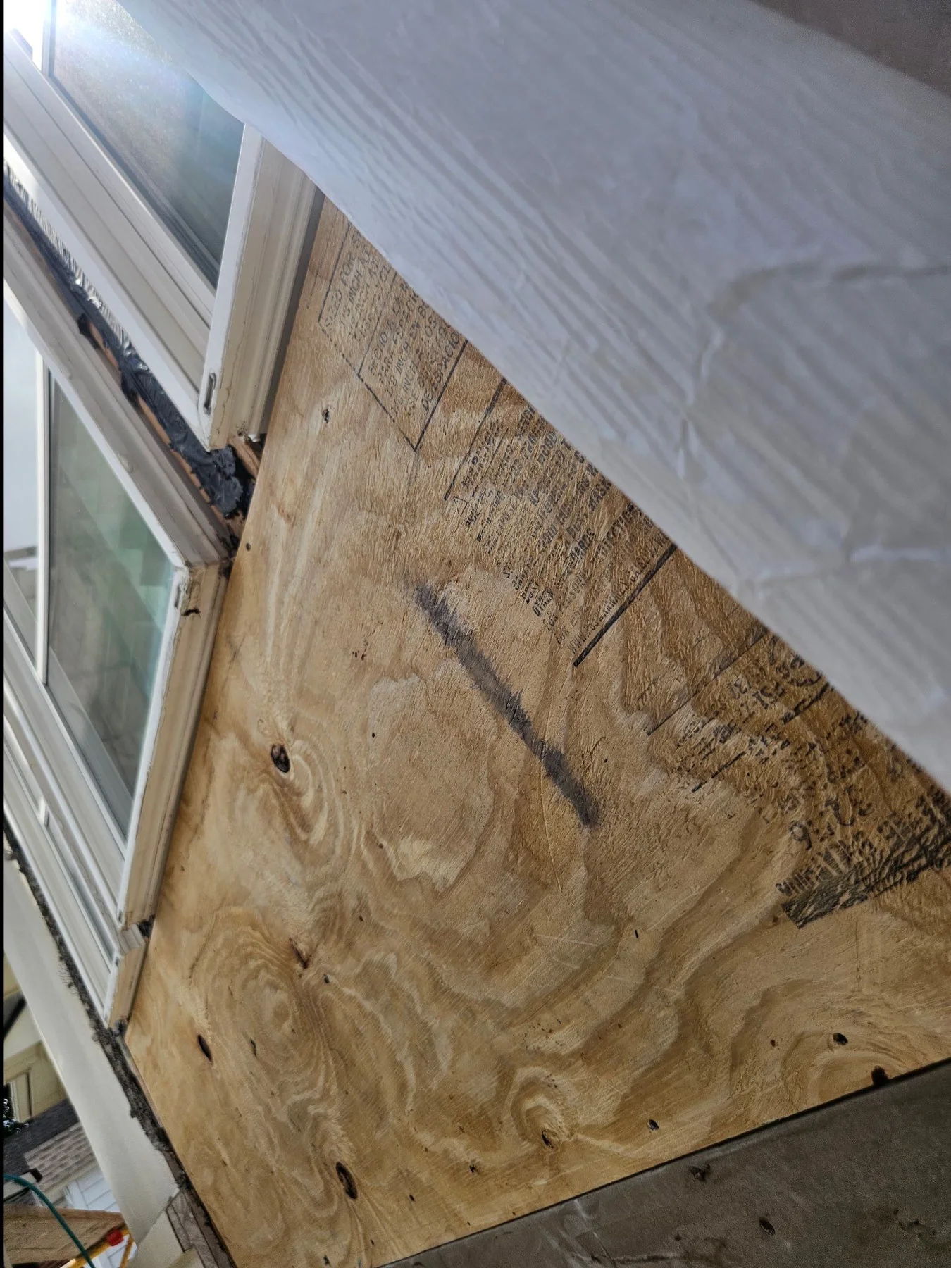 Wood sheathing beside a window during exterior repairs