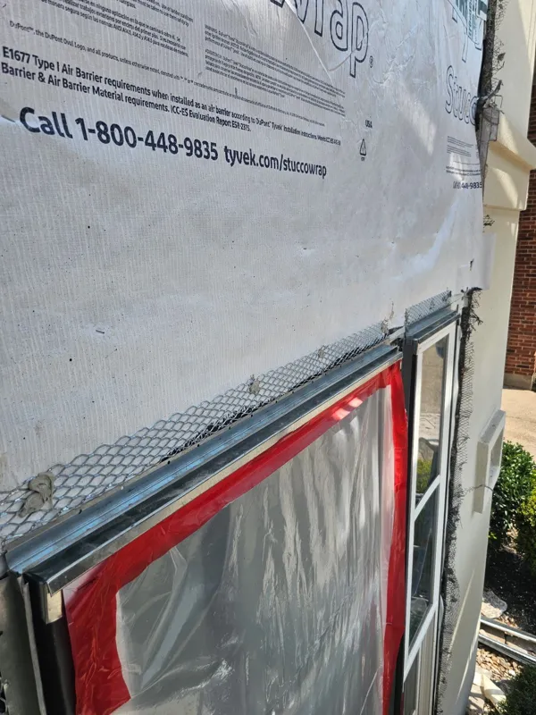 Weather barrier installed beside an exterior window