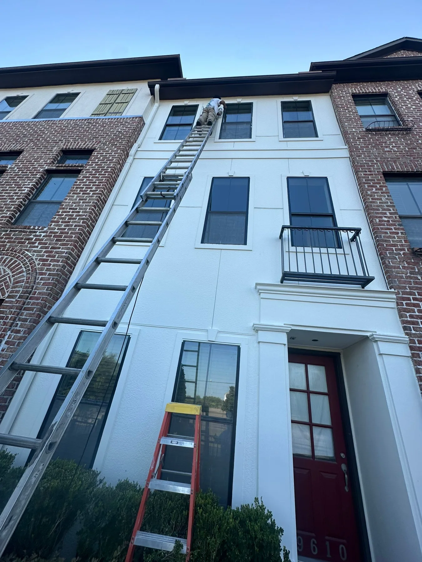 Light stucco and brick townhome exterior after the documented repair stages
