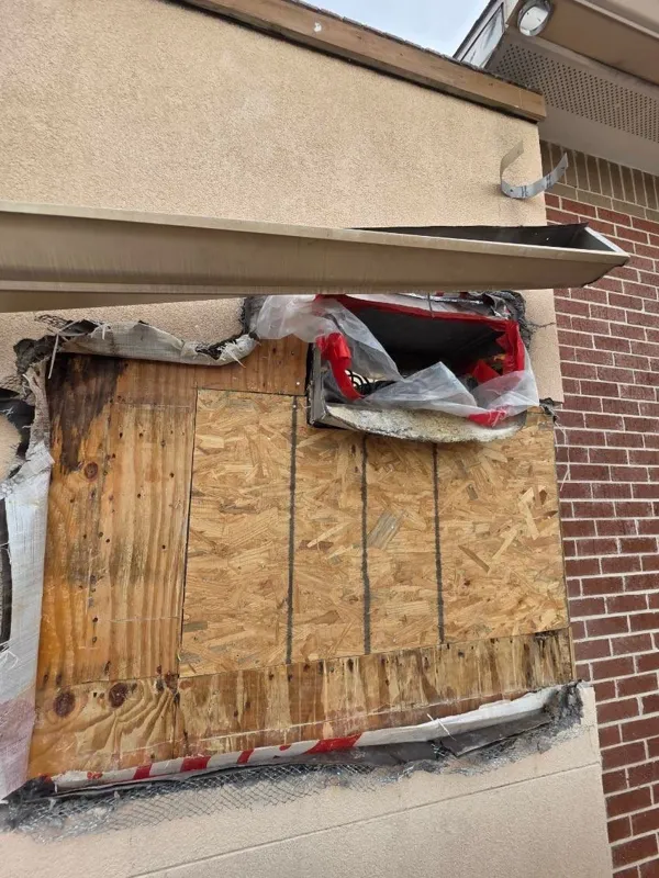 Opened wall and wood sheathing beside brickwork