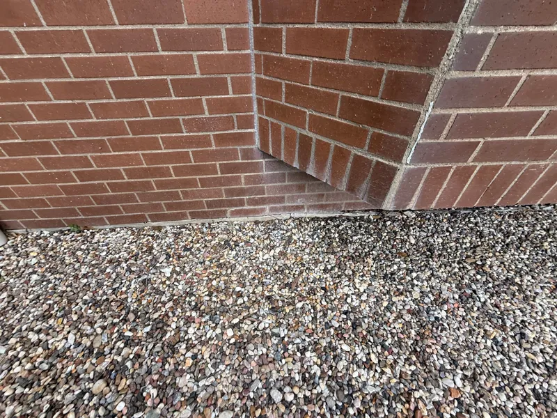 Brick corner and adjacent aggregate paving at ground level