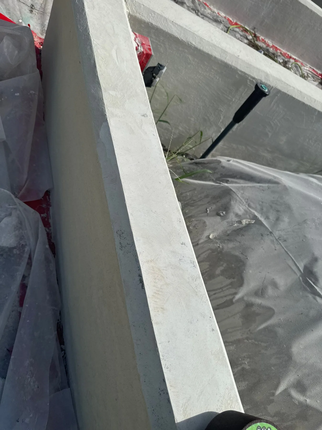 Masked adjacent surfaces beside a stucco painting work area