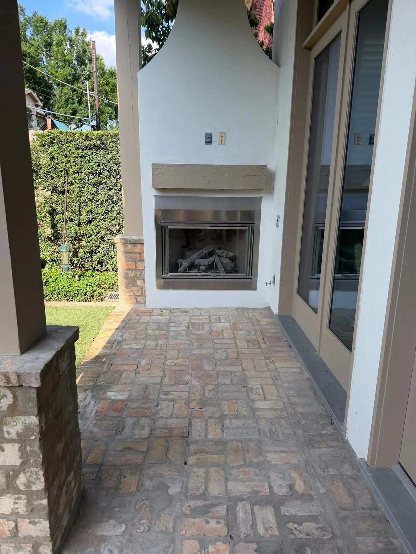 Covered patio wall with window and outdoor fireplace