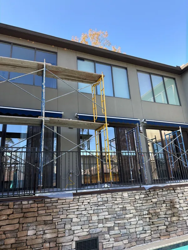 Elevated deck with metal railing beside a stucco wall