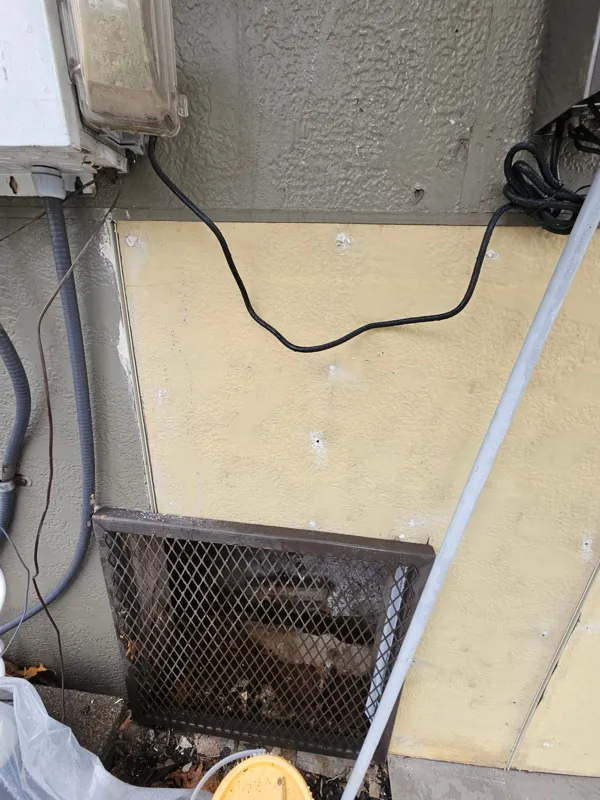 Opened wall and lath beside exterior equipment
