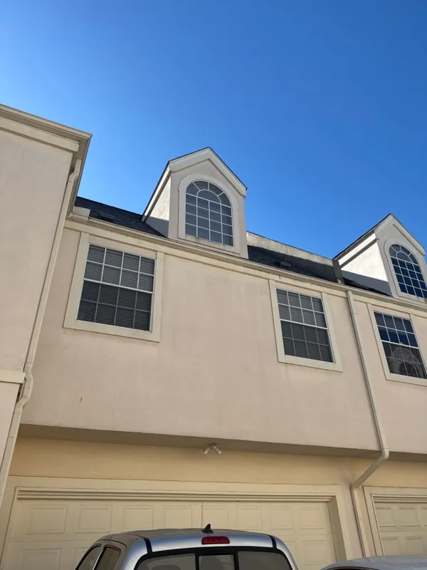 Stucco townhome with a dormer above the garage