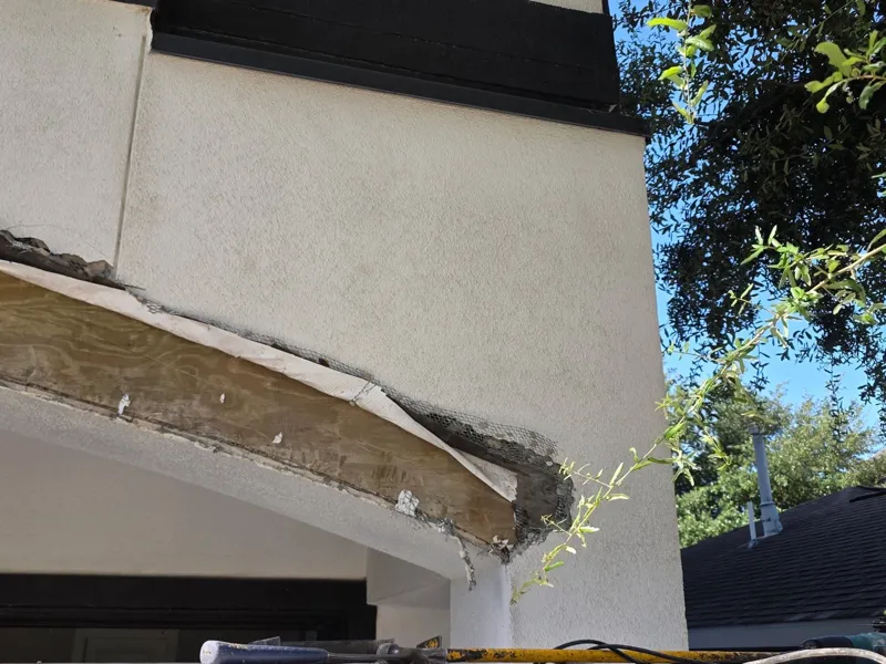 Close view of damaged stucco along the garage arch