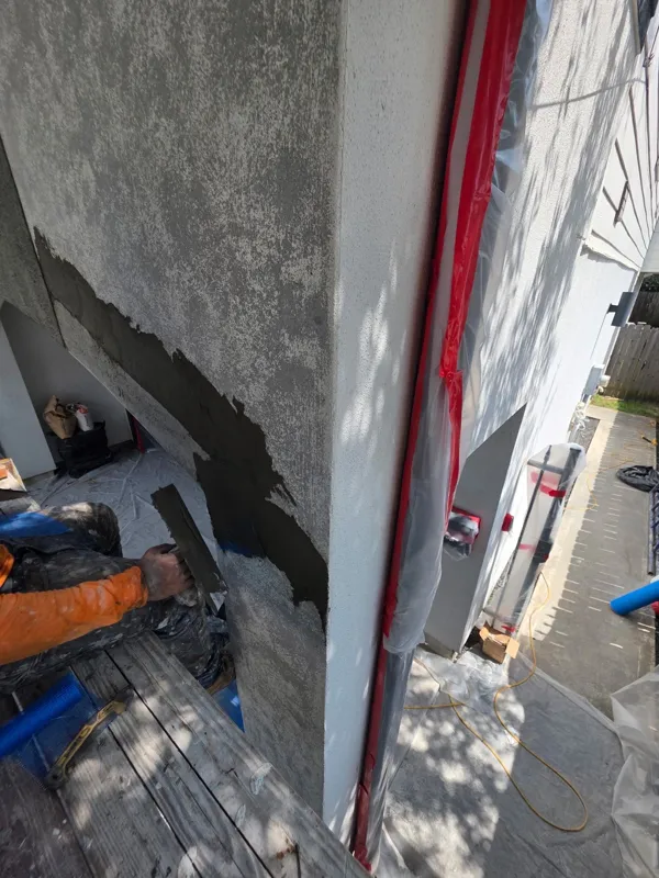 Stucco repair beside a protected window