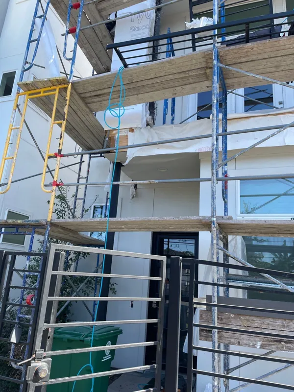 Scaffolding across a multi-story balcony facade