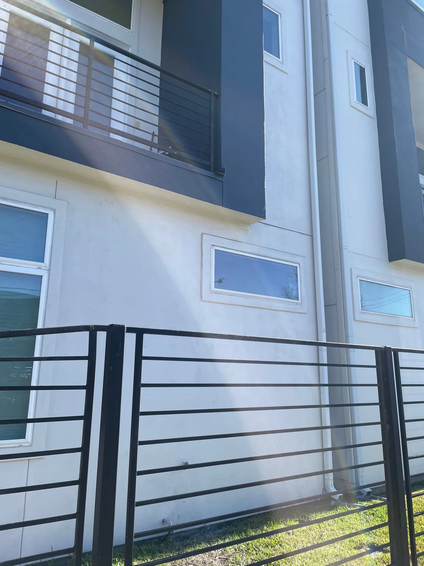 Stucco, balcony railing, and window detail in a later view