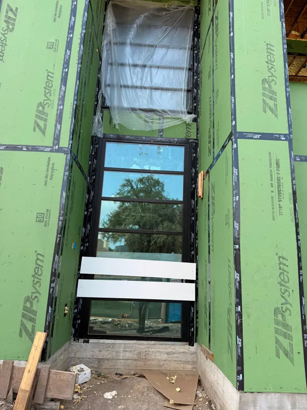 Sheathing around a tall black-framed window