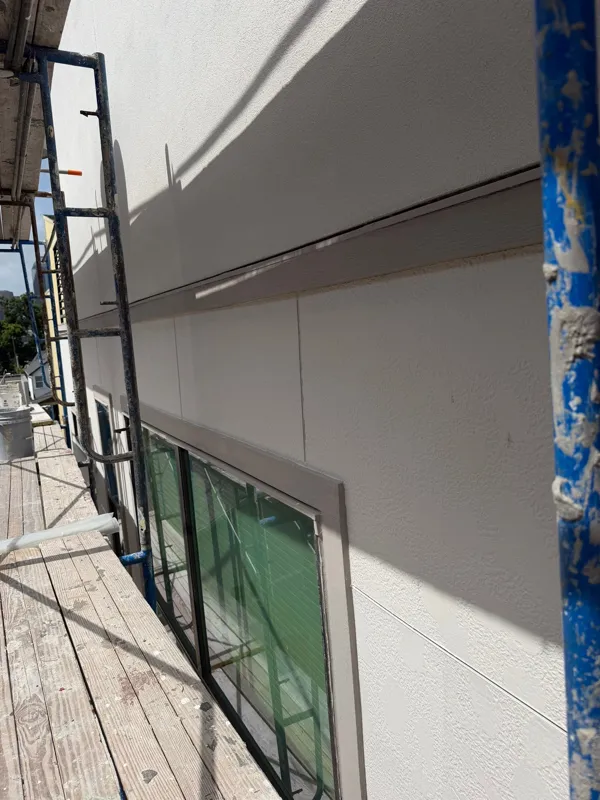 Stucco facade and window beside scaffolding