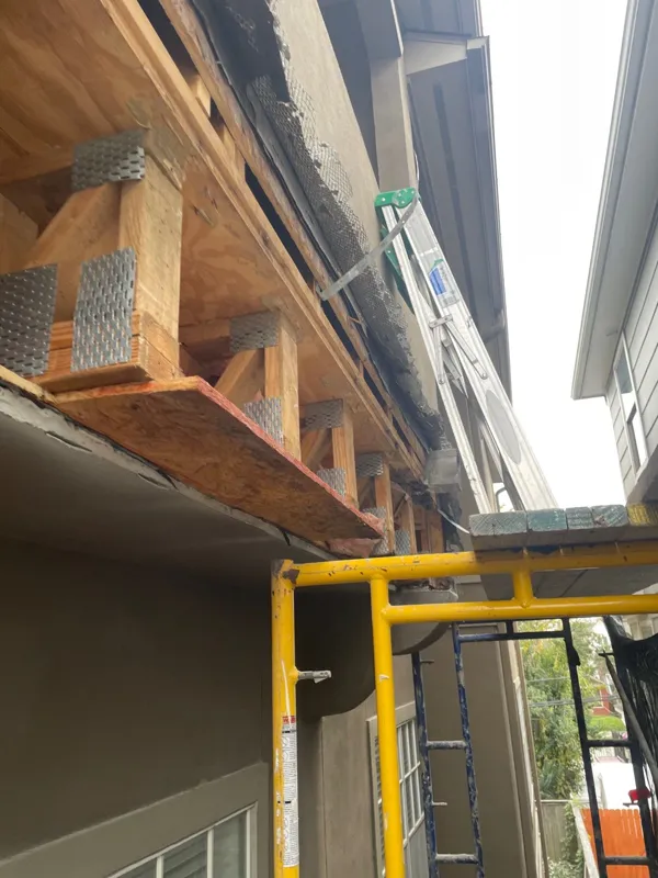 Exposed wood beneath a roof edge during exterior repairs