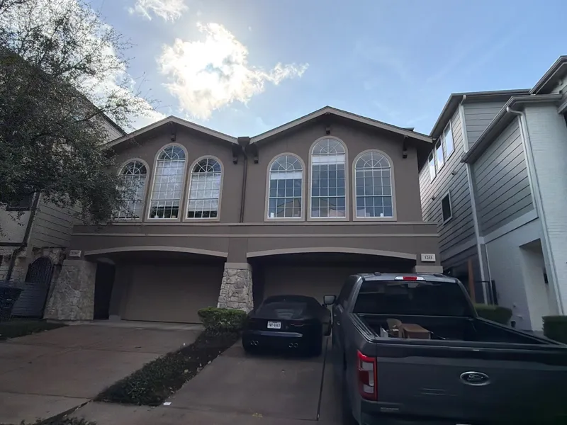 Residential exterior with arched windows and garage doors