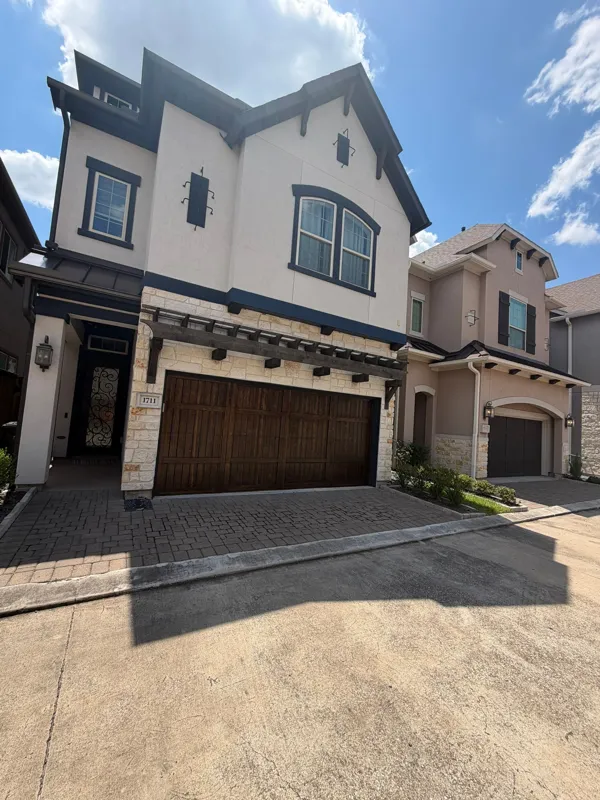 Residential stucco exterior viewed from the driveway