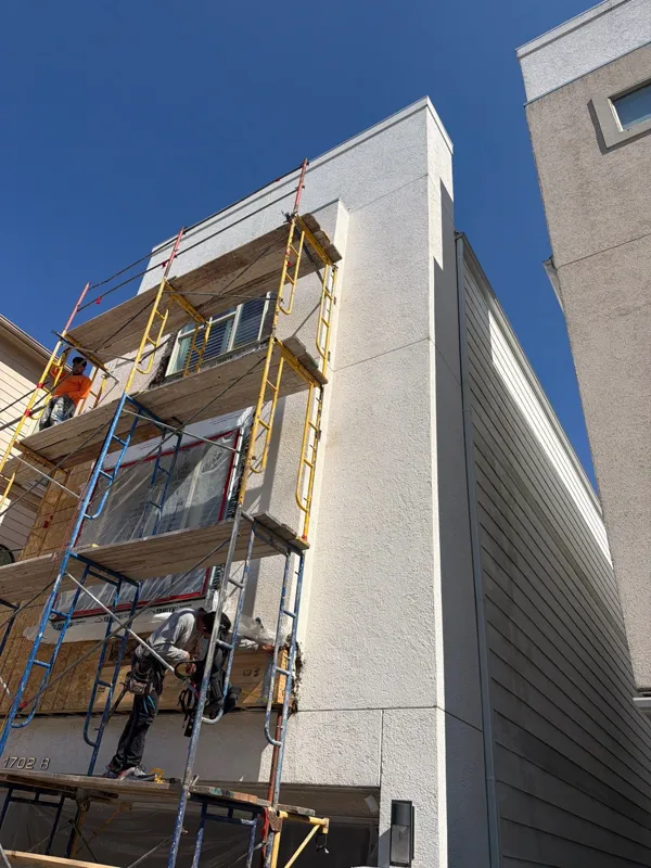 Scaffolding against a tall stucco townhouse