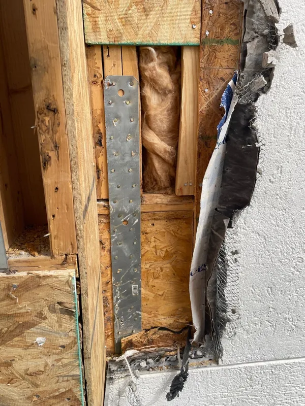 Wood framing visible behind removed stucco
