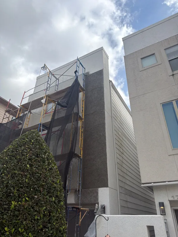 Upper facade with scaffolding and protective covering