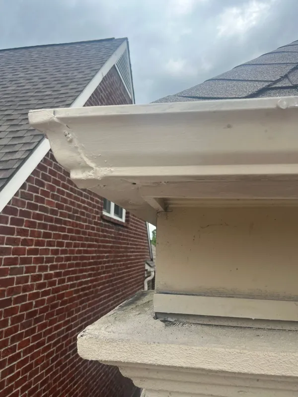 Stucco wall and roof-edge detail beside brickwork