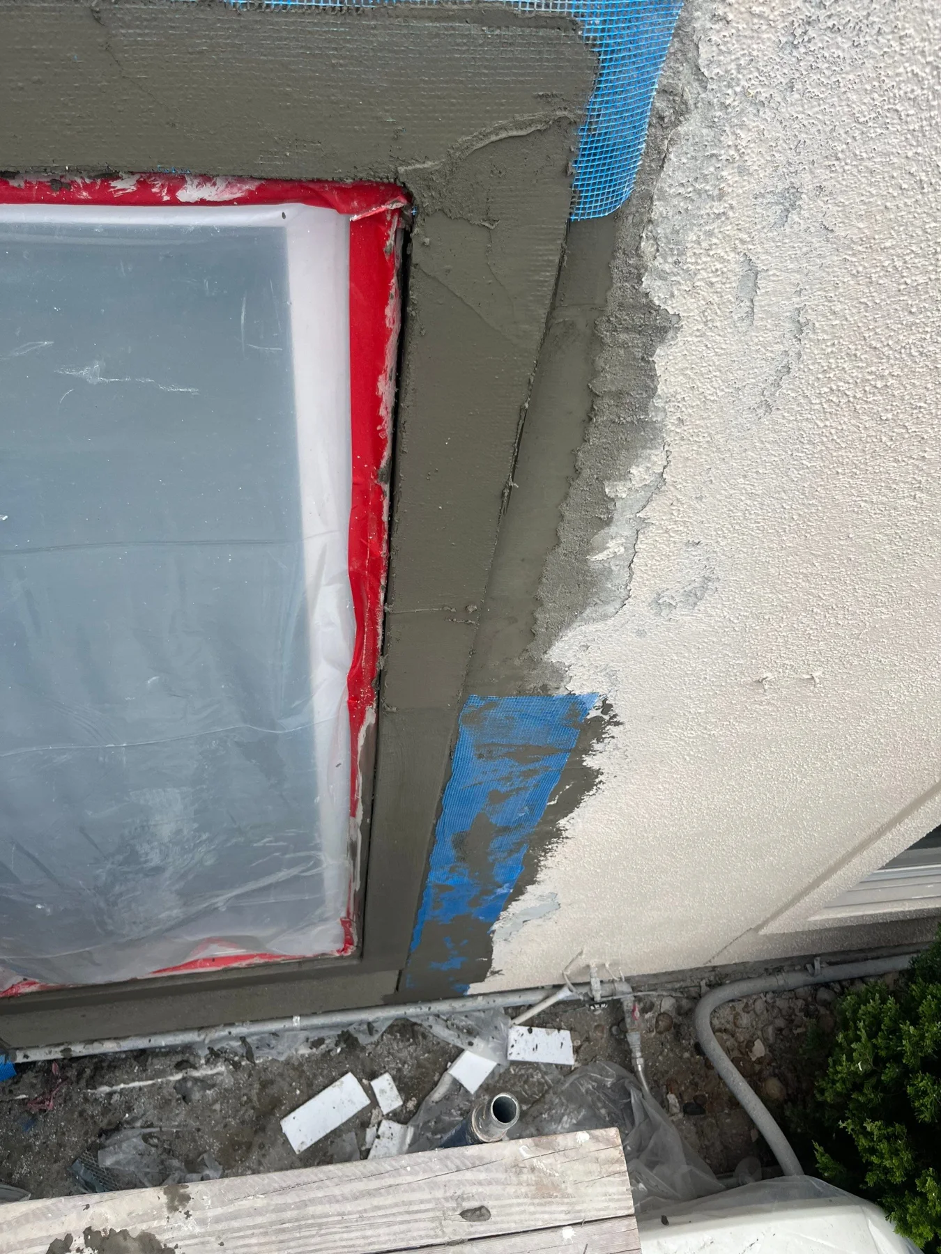 Fresh stucco work around a masked window