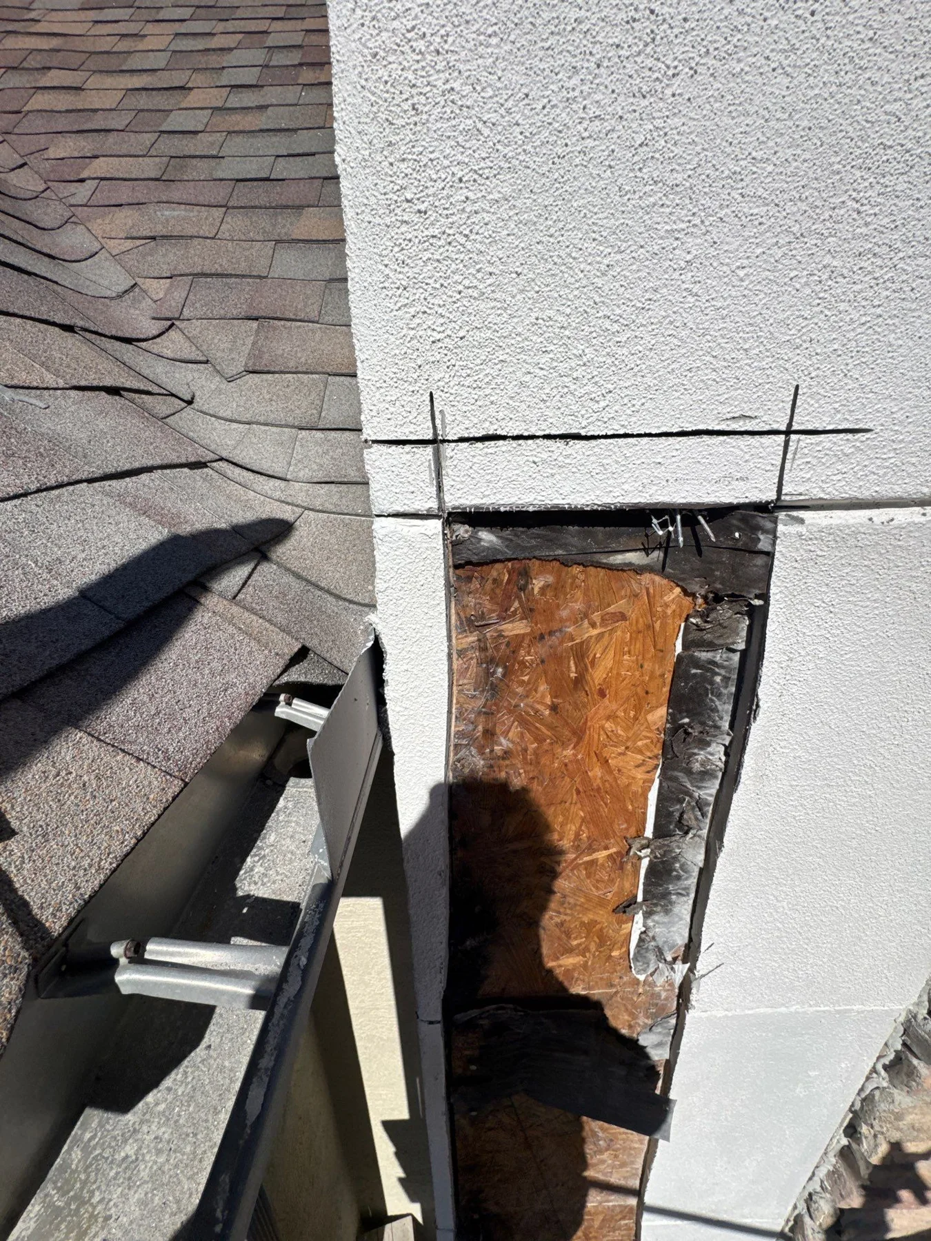 Exposed wood where the stucco wall meets the roof