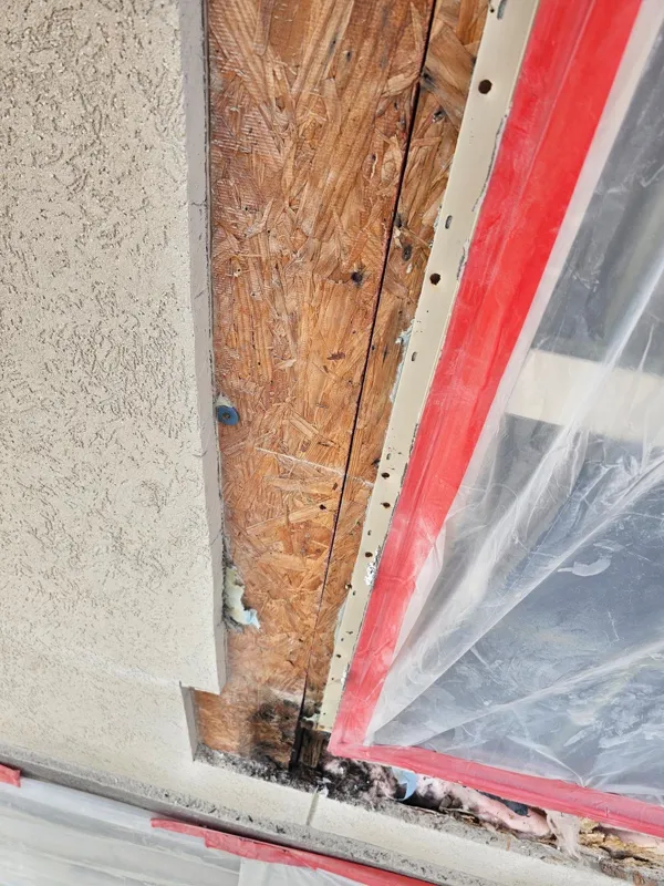 Wood sheathing exposed alongside a protected window