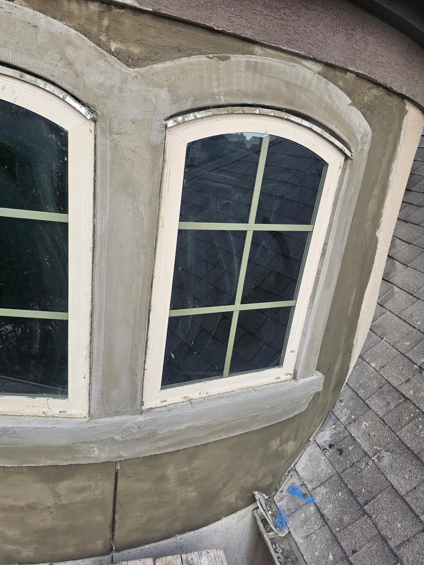 Light-colored stucco surrounding a curved bay window