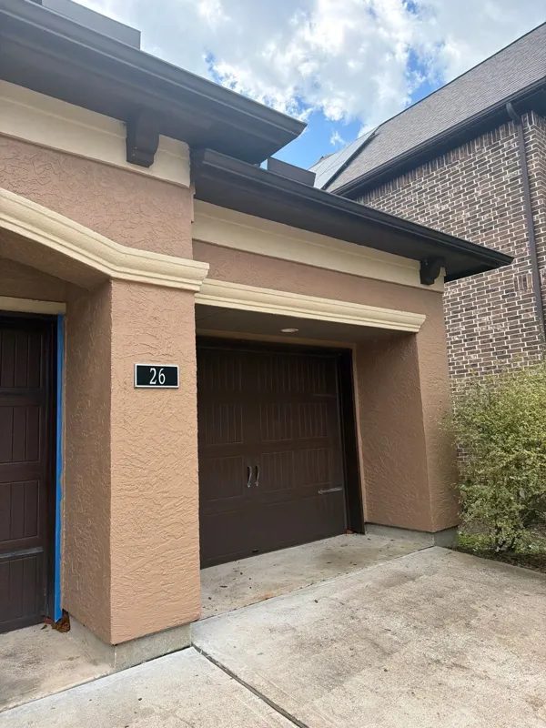 Later view of the garage-side stucco and entry