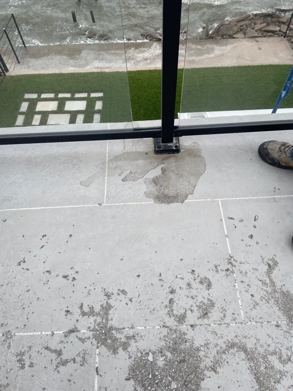 Worn balcony surface beside a glass railing