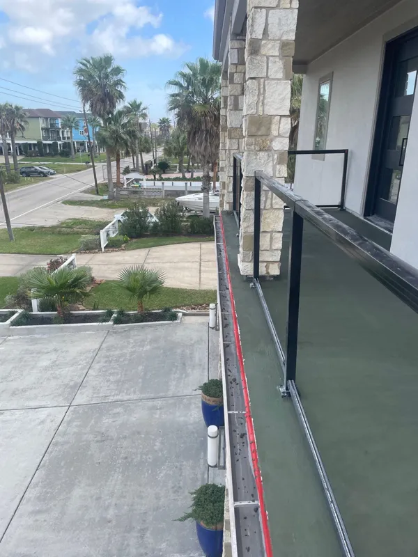 Prepared balcony surface and railing viewed along the building