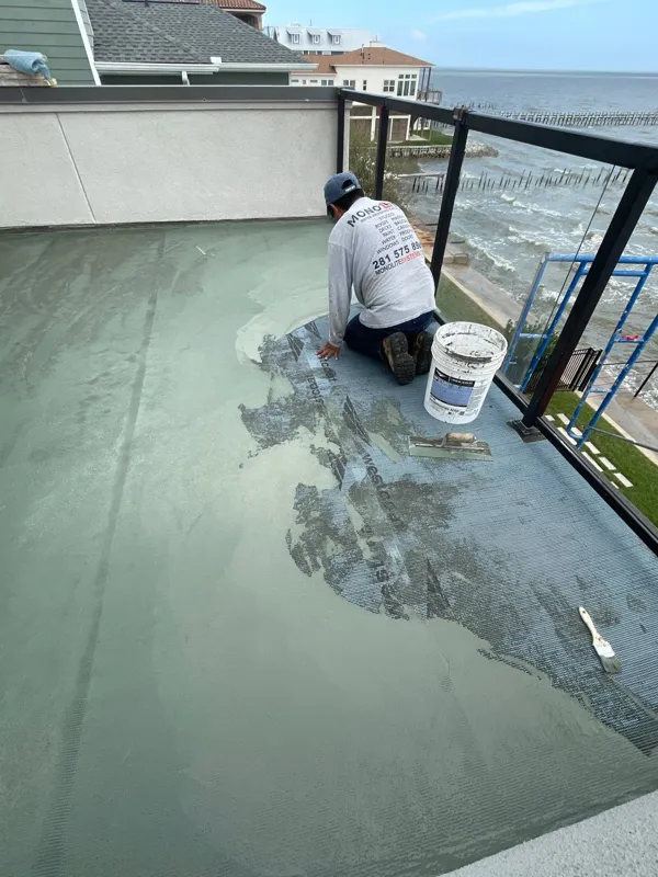 Worker applying material to the balcony surface