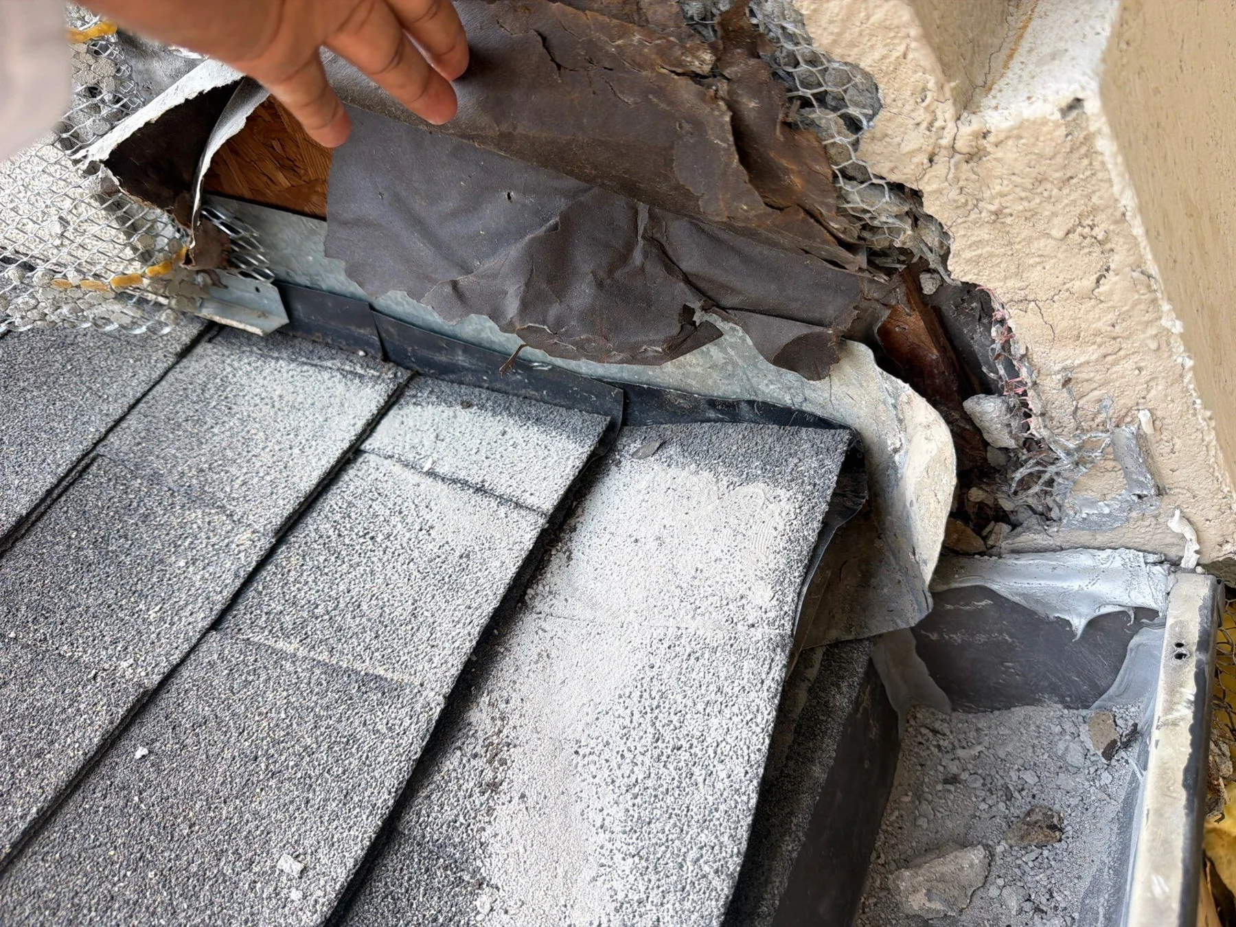 Opened material where the roof meets the stucco wall