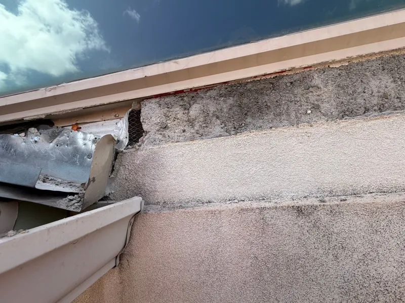 Opened stucco along a horizontal trim detail