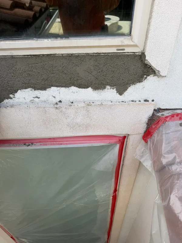 Stucco repair work beneath a protected window