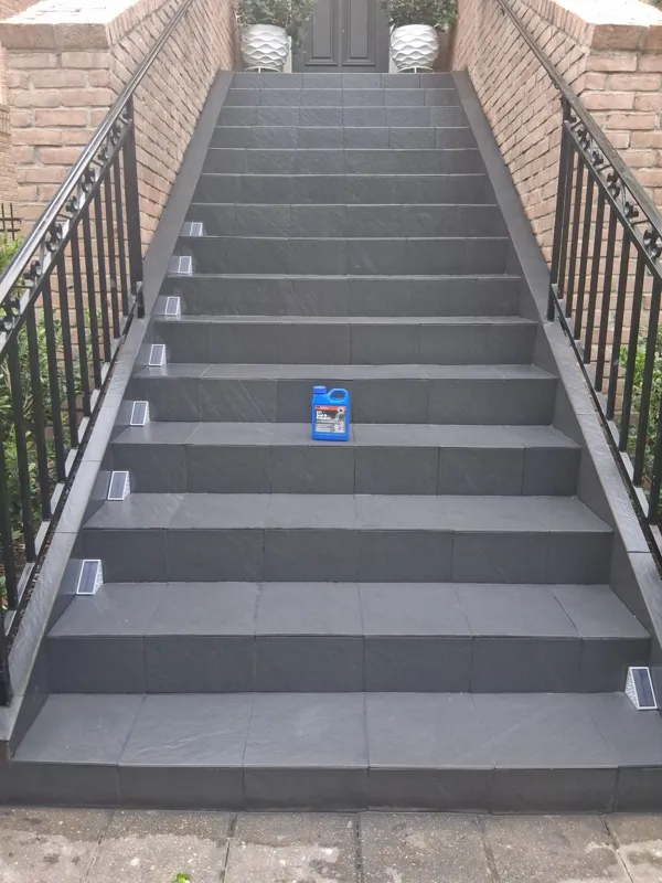 Gray outdoor stair treads between brick walls