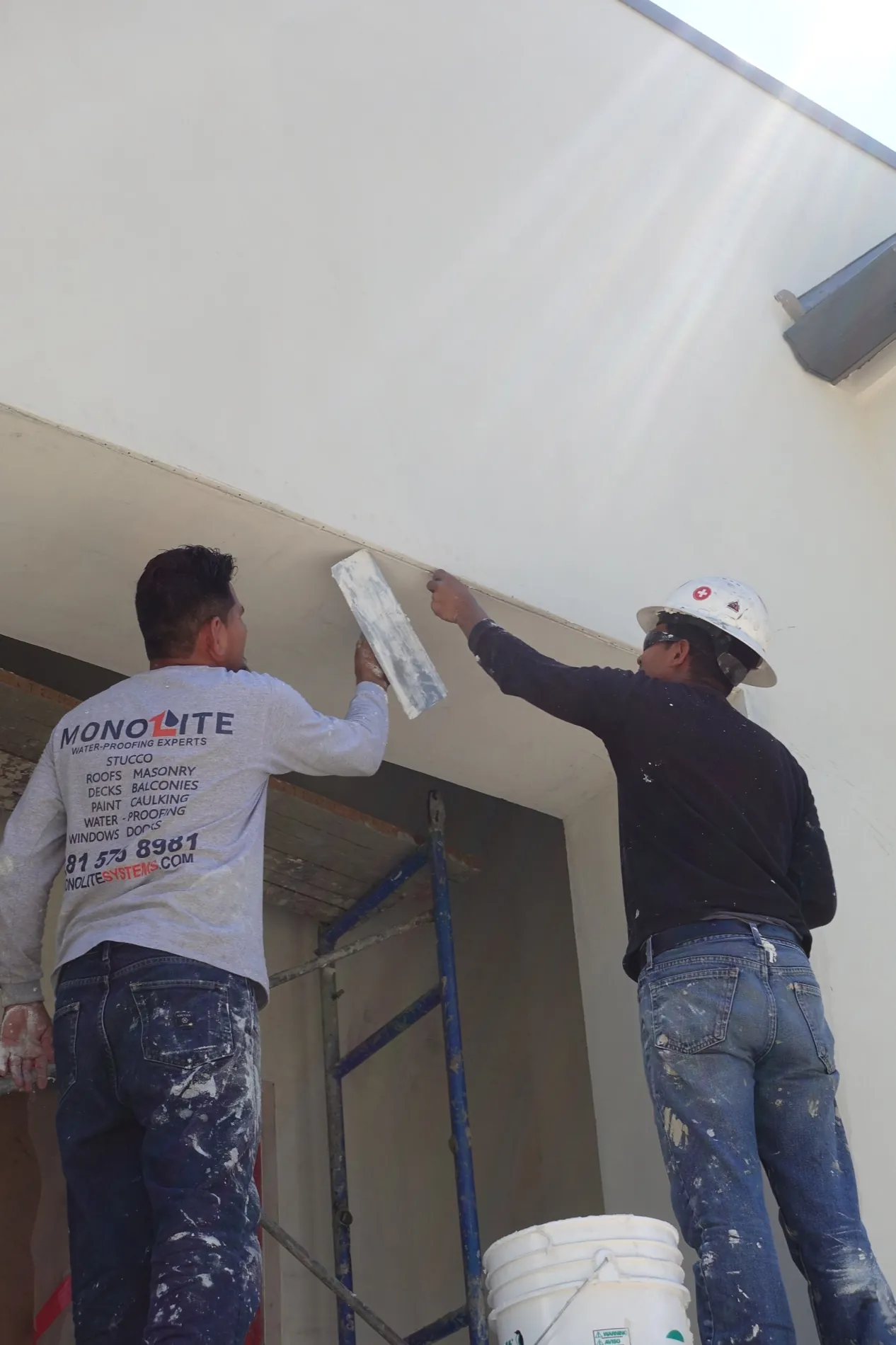 Monolite craftsmen applying stucco to a custom home exterior